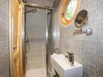 a bathroom with a sink and a shower at Woodland Pod in Corwen