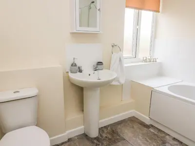 a white bathroom with a sink and a toilet at Lower Pentre in Llandrindod Wells
