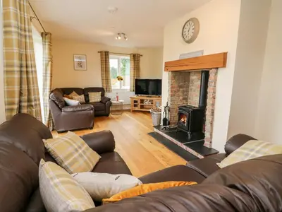a living room with a couch and a fireplace at Lower Pentre in Llandrindod Wells