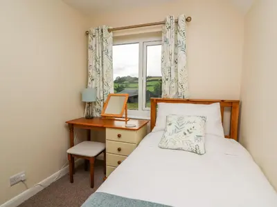 a bedroom with a bed and a desk and a window at Lower Pentre in Llandrindod Wells