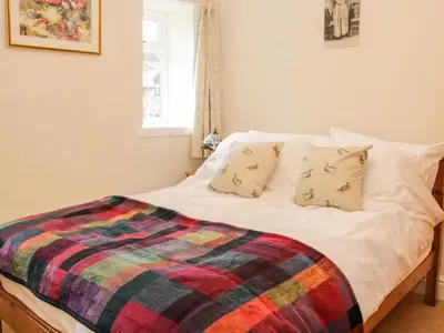 a bed with a colorful blanket on top of it at Bryn Celyn in Oswestry