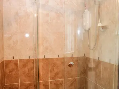 a shower with a glass door and a shower at Bryn Celyn in Oswestry