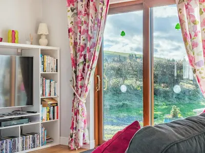 a living room with a large window and a couch at Cuckoo Hill Lodge in Saint Harmon