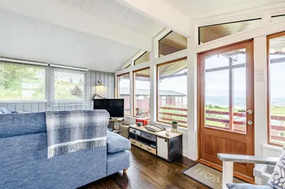 a living room with a blue couch and a television at The Look Out in Aberdyfi