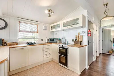 a kitchen with white cabinets and a stove top oven at The Look Out in Aberdyfi