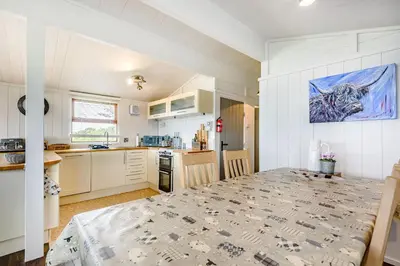a kitchen and dining room with a table in a room at The Look Out in Aberdyfi