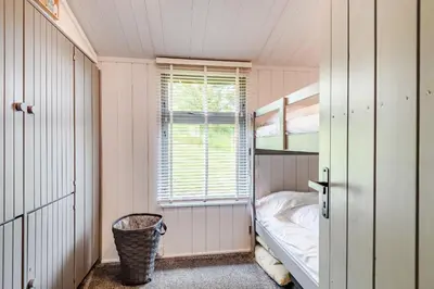 a small room with a bunk bed and a window at The Look Out in Aberdyfi