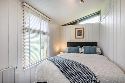 a bedroom with a large bed with a window at The Look Out in Aberdyfi