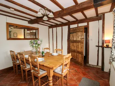 a dining room with a wooden table and chairs at Wilstone Cottage in Church Stretton