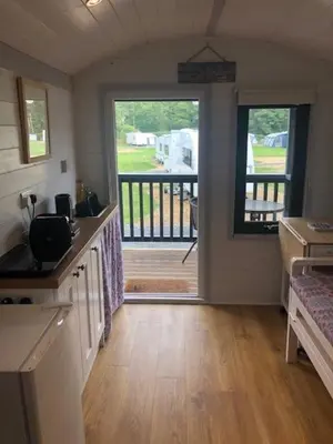 a kitchen with an open door to a deck at Shepherds Hut at Wern Mill in New Quay