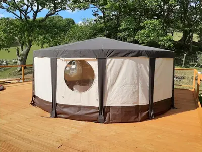 a black and white tent on a wooden deck at Cae Mawr Yurt Off-Grid Glamping in Machynlleth