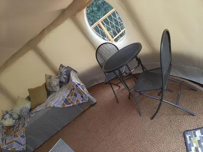 an attic room with a bed and a window at Cae Mawr Yurt Off-Grid Glamping in Machynlleth