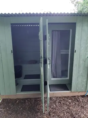 a green out house with a door and a window at Cae Mawr Yurt Off-Grid Glamping in Machynlleth