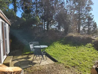 a patio with a table and two chairs in a yard at Foxs Lair Aberdovey in Aberdyfi