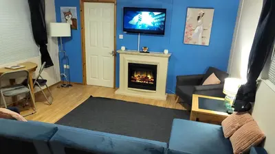 a living room with a couch and a fireplace at Foxs Lair Aberdovey in Aberdyfi