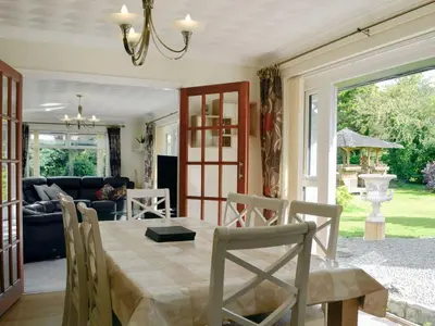 a dining room with a table and a couch at Tan y Gaer in Aberystwyth