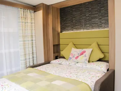 a bedroom with a bed with a green headboard at Jacob's Meadow in Shrewsbury