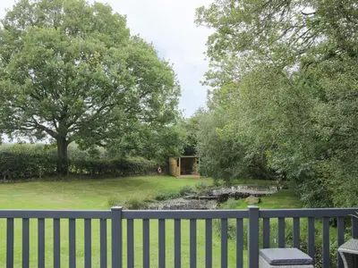 a garden with a fence and a pond at Jacob's Meadow in Shrewsbury