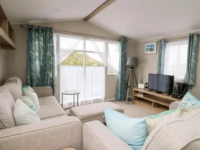 a living room with a couch and a tv at Ystwyth 26 in Borth