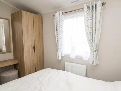 a bedroom with a bed and a window at Ystwyth 26 in Borth