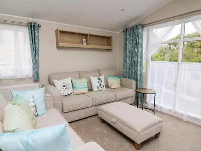 a living room with a couch and a chair at Ystwyth 26 in Borth