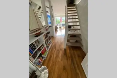 a hallway with a staircase and a book shelf at The Little Boat House in Talsarnau