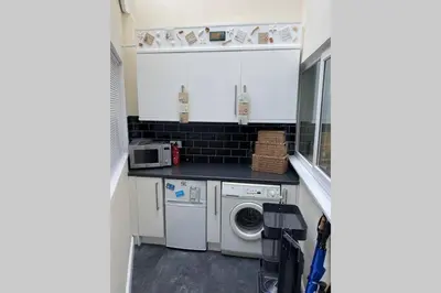 a small kitchen with a washing machine and a washer at The Little Boat House in Talsarnau