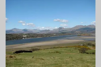 a large body of water with mountains in the background at The Little Boat House in Talsarnau