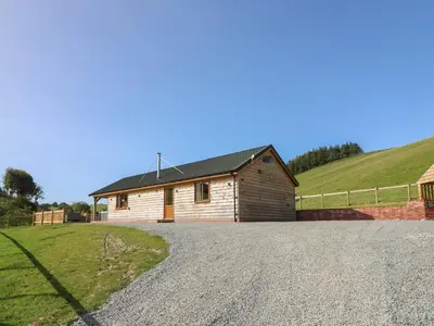 a house with a gravel driveway in front of it at Ploony Hill Cabin in Knighton
