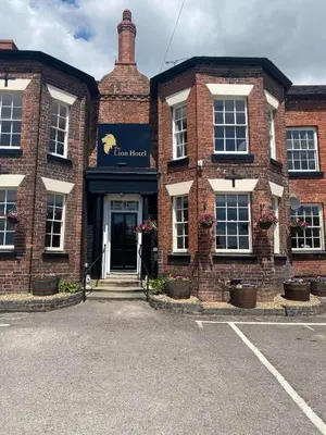 a brick building with a sign on the front of it at The Lion Hotel in Llansantffraid-ym-Mechain
