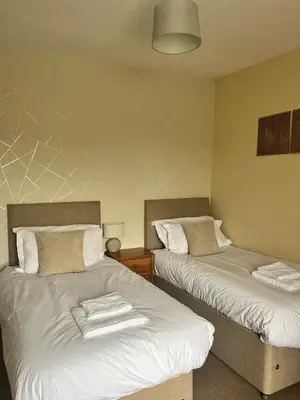 a room with two beds with towels on them at The Lion Hotel in Llansantffraid-ym-Mechain