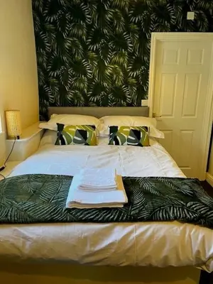 a bedroom with a bed with a black and white blanket at The Lion Hotel in Llansantffraid-ym-Mechain