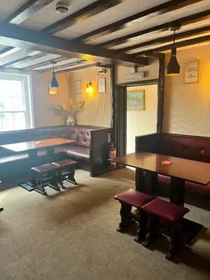 a room with a table and benches and a couch at The Lion Hotel in Llansantffraid-ym-Mechain
