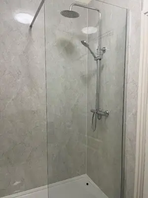 a shower stall with a glass shower door at The Lion Hotel in Llansantffraid-ym-Mechain