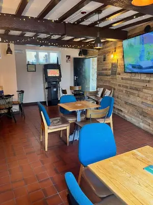 a dining room with tables and chairs and a screen at The Lion Hotel in Llansantffraid-ym-Mechain