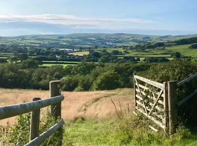 a gate on a hill with a view at Snowdonia Hideaway in Tywyn
