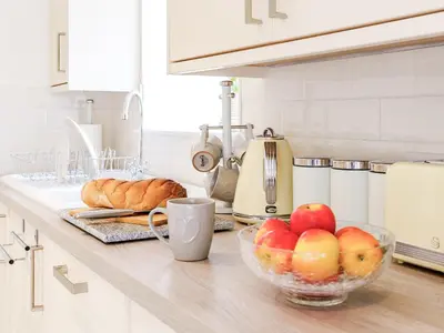 a kitchen counter with a bowl of apples and bread at Ty Draenog - Uk31653 in New Quay