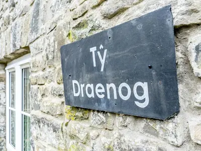 a sign on the side of a stone building at Ty Draenog - Uk31653 in New Quay