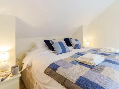 a bedroom with a bed with a blue and white blanket at Ty Arth - Uk31652 in New Quay