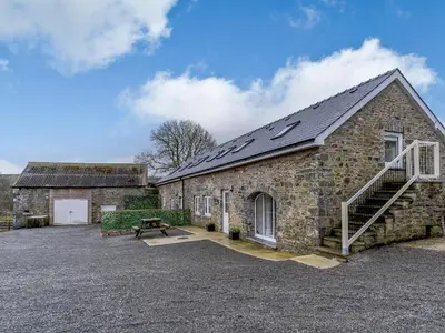 a stone building with a bench in front of it at Ty Arth - Uk31652 in New Quay