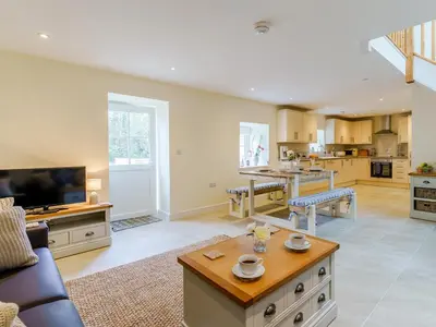 a large kitchen and living room with a couch and a table at Ty Arth - Uk31652 in New Quay