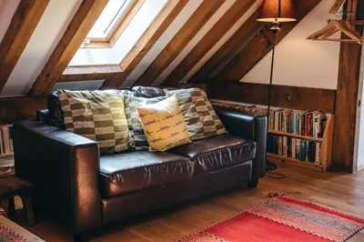 a leather couch with pillows in a living room at the garden room in Shrewsbury