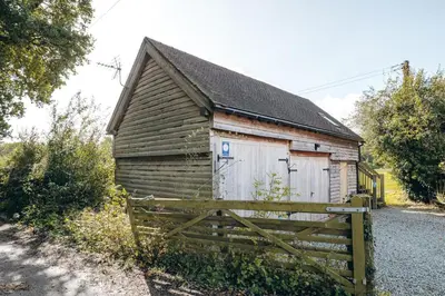 an old wooden building with a fence in front of it at the garden room in Shrewsbury