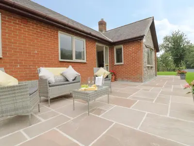 a patio with two chairs and a table at Hendre in Oswestry