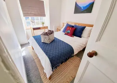 a bedroom with a bed with blue and red pillows at Eldon Row - Stylish Character Apartments - Central Location 1 & 2 bed available in Dolgellau