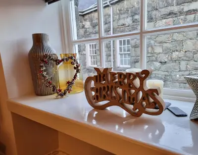 a window sill with a happy christmas sign and a vase at Eldon Row - Stylish Character Apartments - Central Location 1 & 2 bed available in Dolgellau