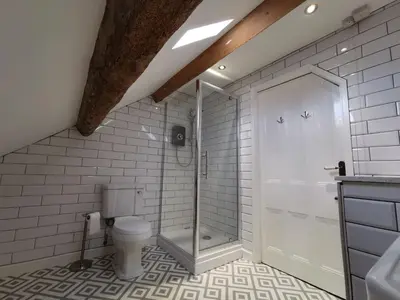 a bathroom with a toilet and a glass shower at Eldon Row - Stylish Character Apartments - Central Location 1 & 2 bed available in Dolgellau
