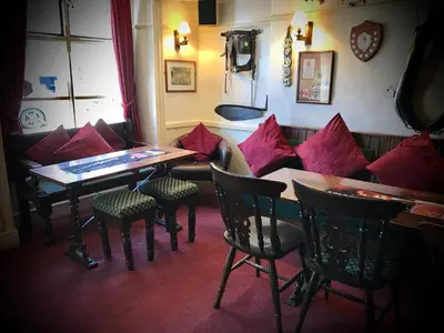 a restaurant with a table and chairs with red pillows at The White Horse Inn, Clun in Clun