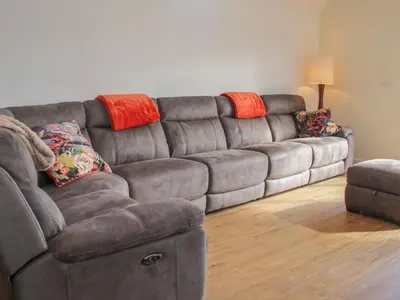 a brown leather couch in a living room at Black Lion Barn Retreat in Shrewsbury