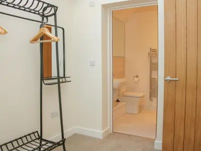 a room with a bathroom with a toilet and a shelf at Black Lion Barn Retreat in Shrewsbury